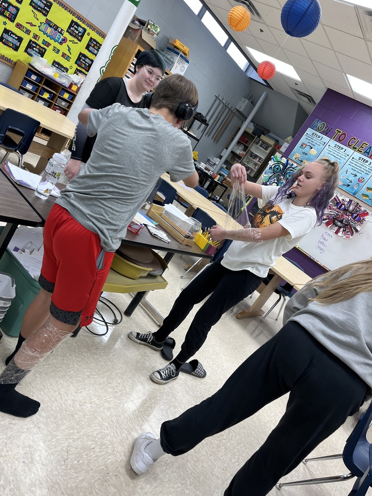 Students wrapping their arms and legs with tape. 