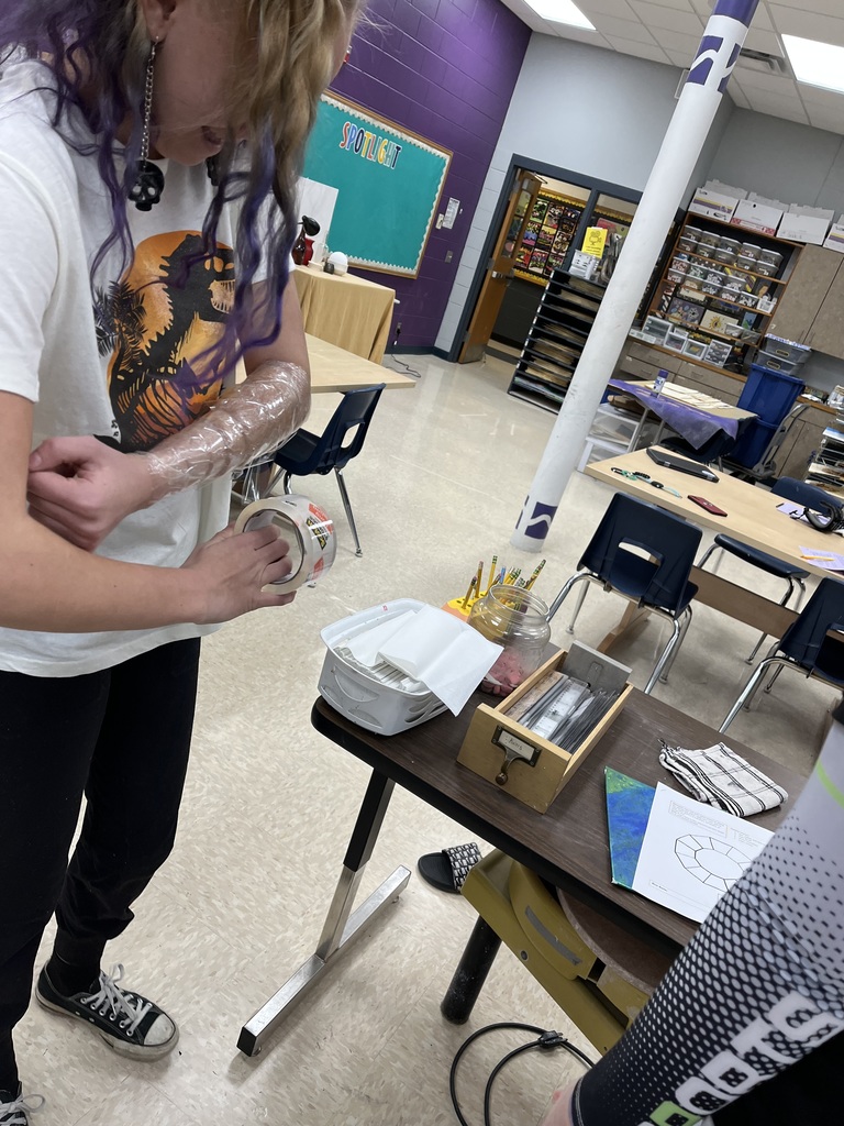 Student wrapping her arm with tape. 